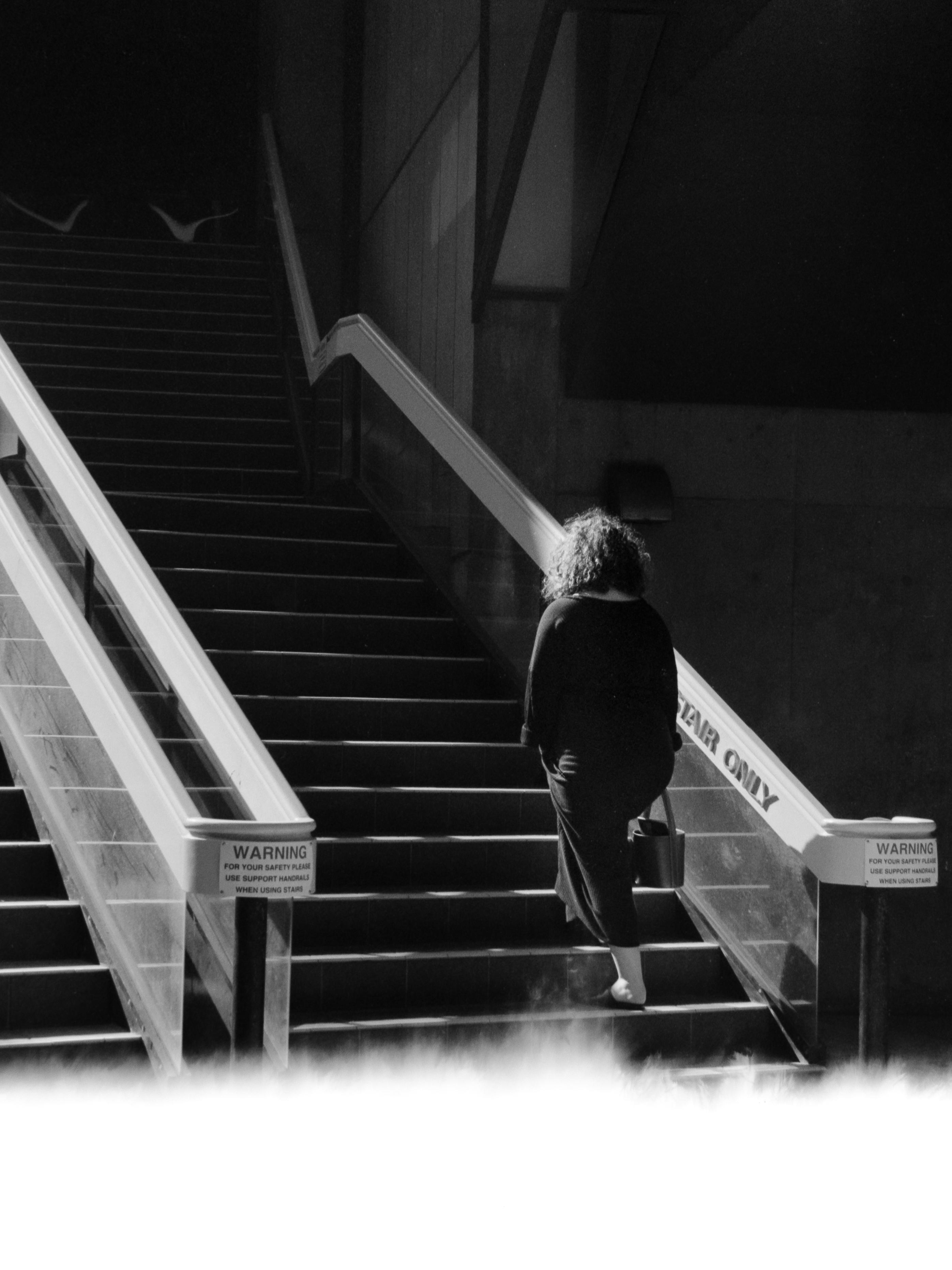 Photo of a woman walking up stairs, with first-of-frame film burn below 