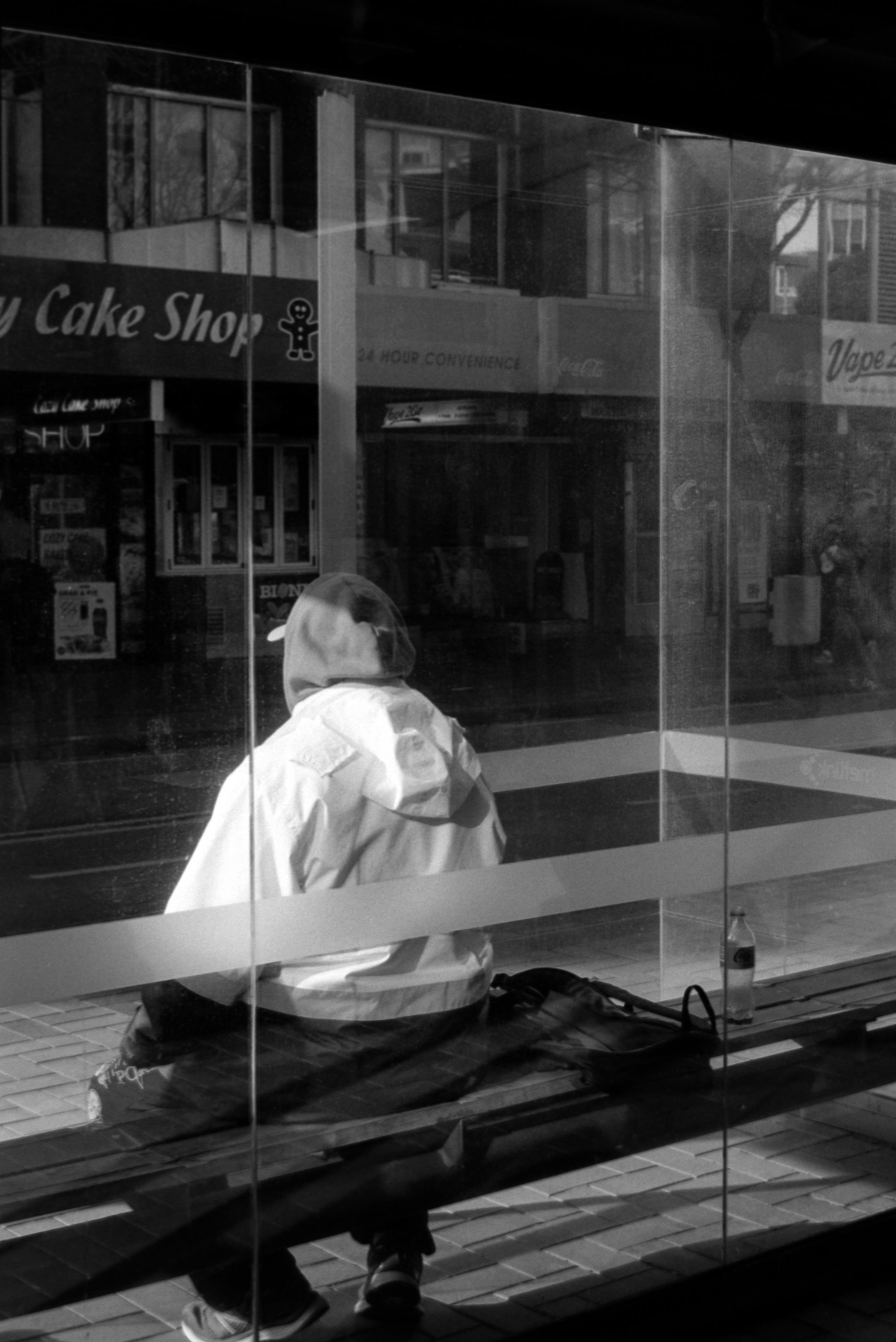 Photo of a man sittting at a bus stop 