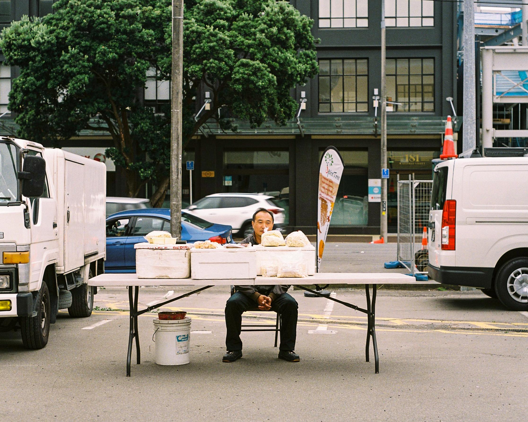 Photo of a man selling dumplings at a market 