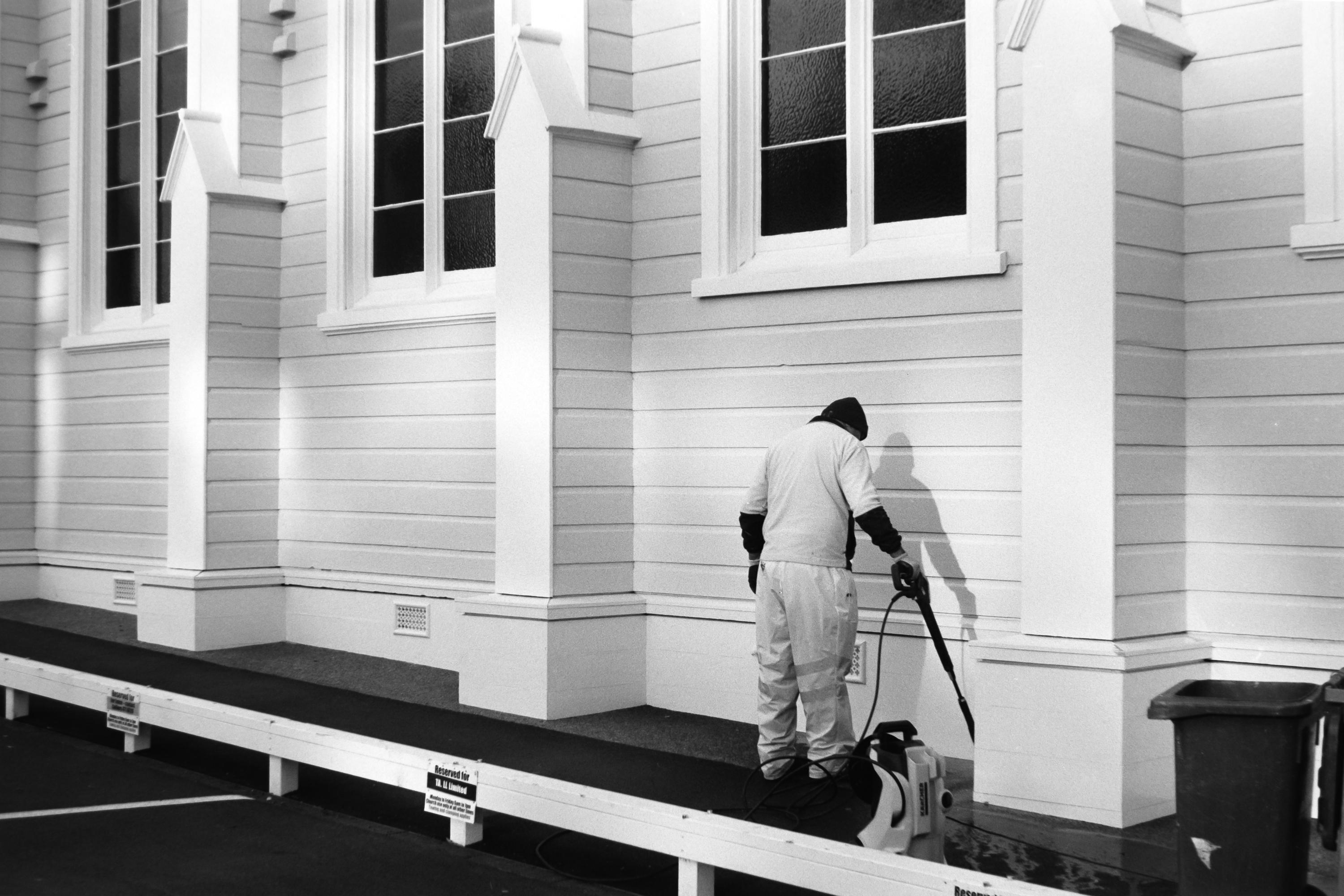 Photo of a man cleaning the side of a building 