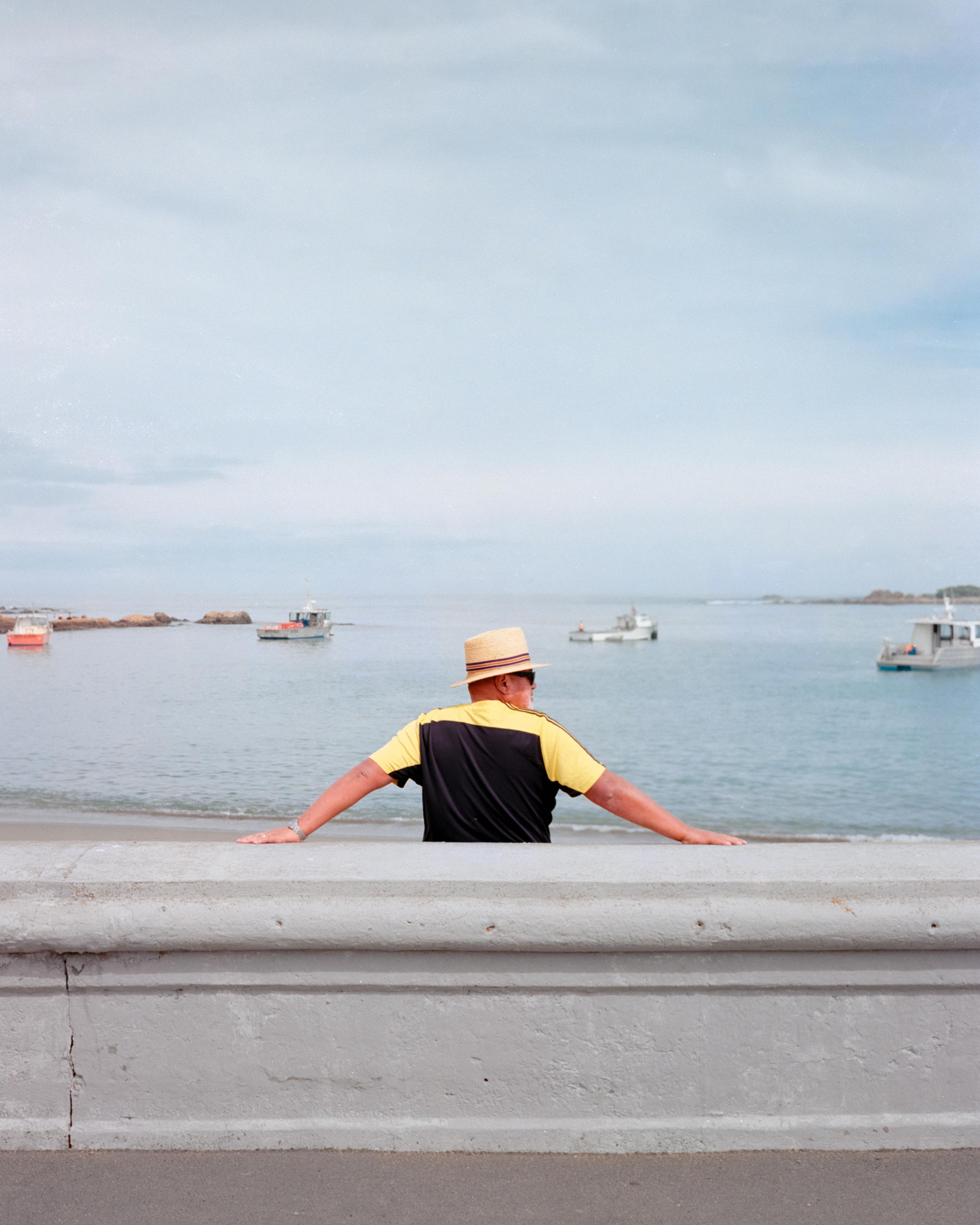Photo of a man leaning against a sea wall