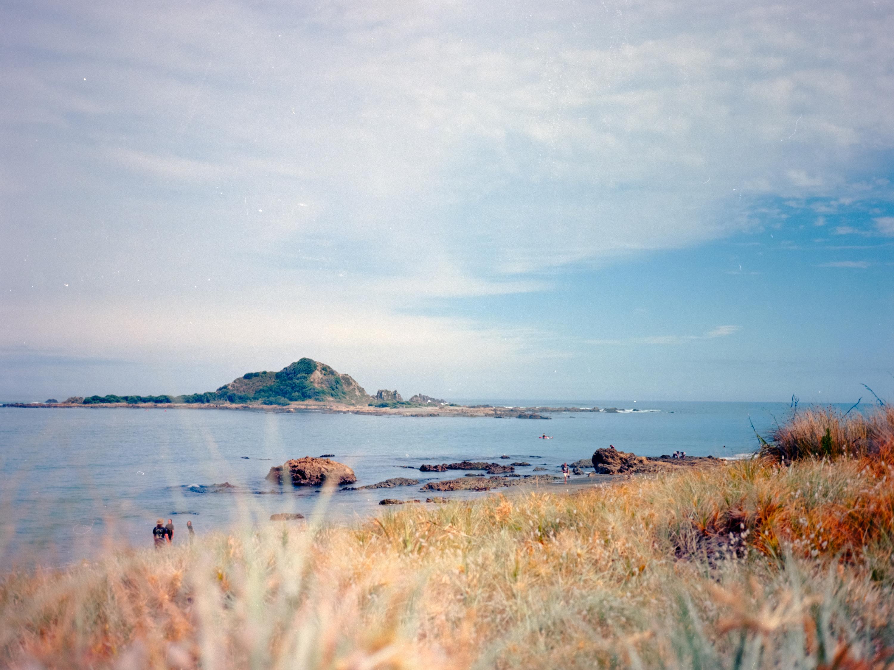 Photo of a beach with an island in the distance 