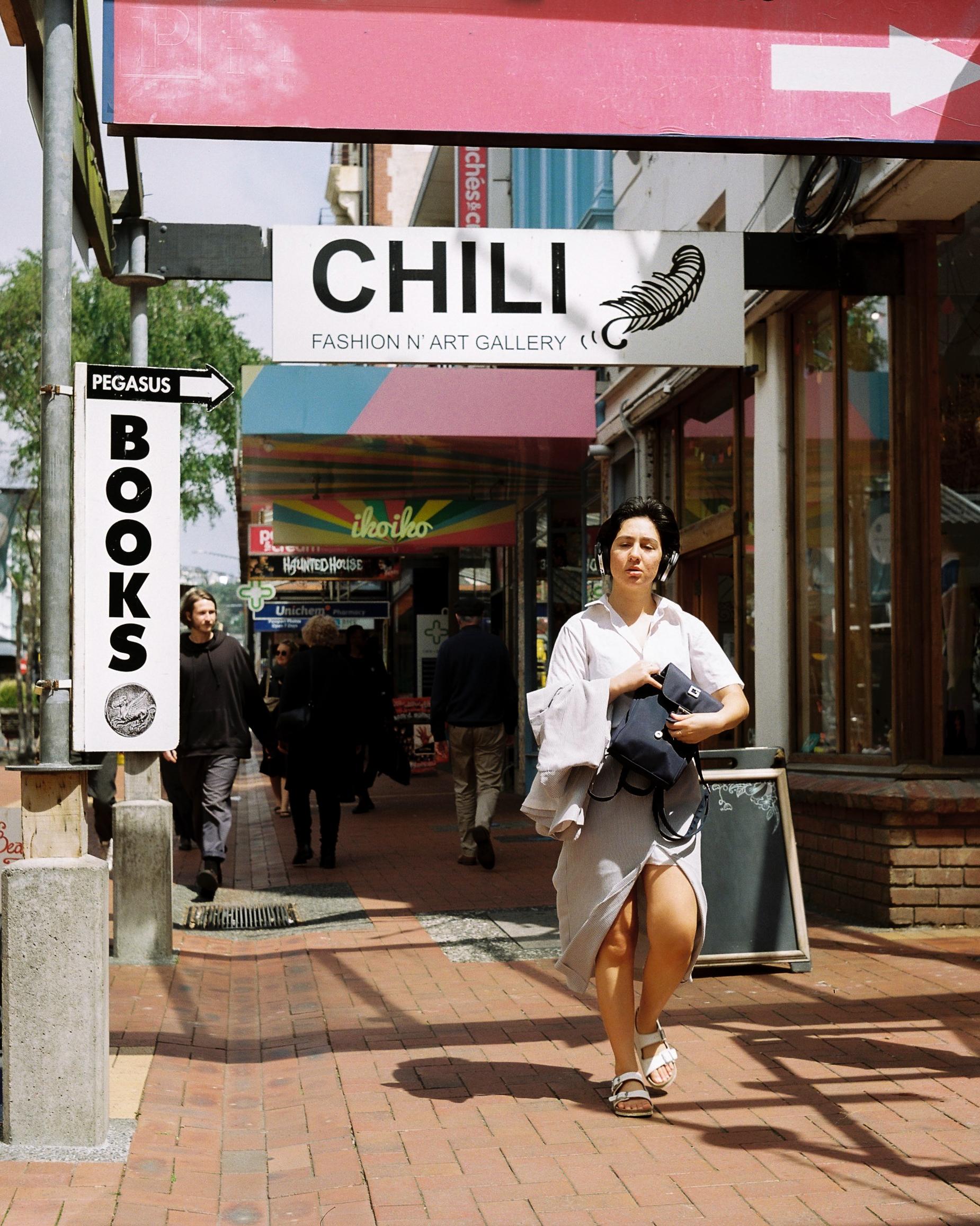 Photo of a woman passing a sign 