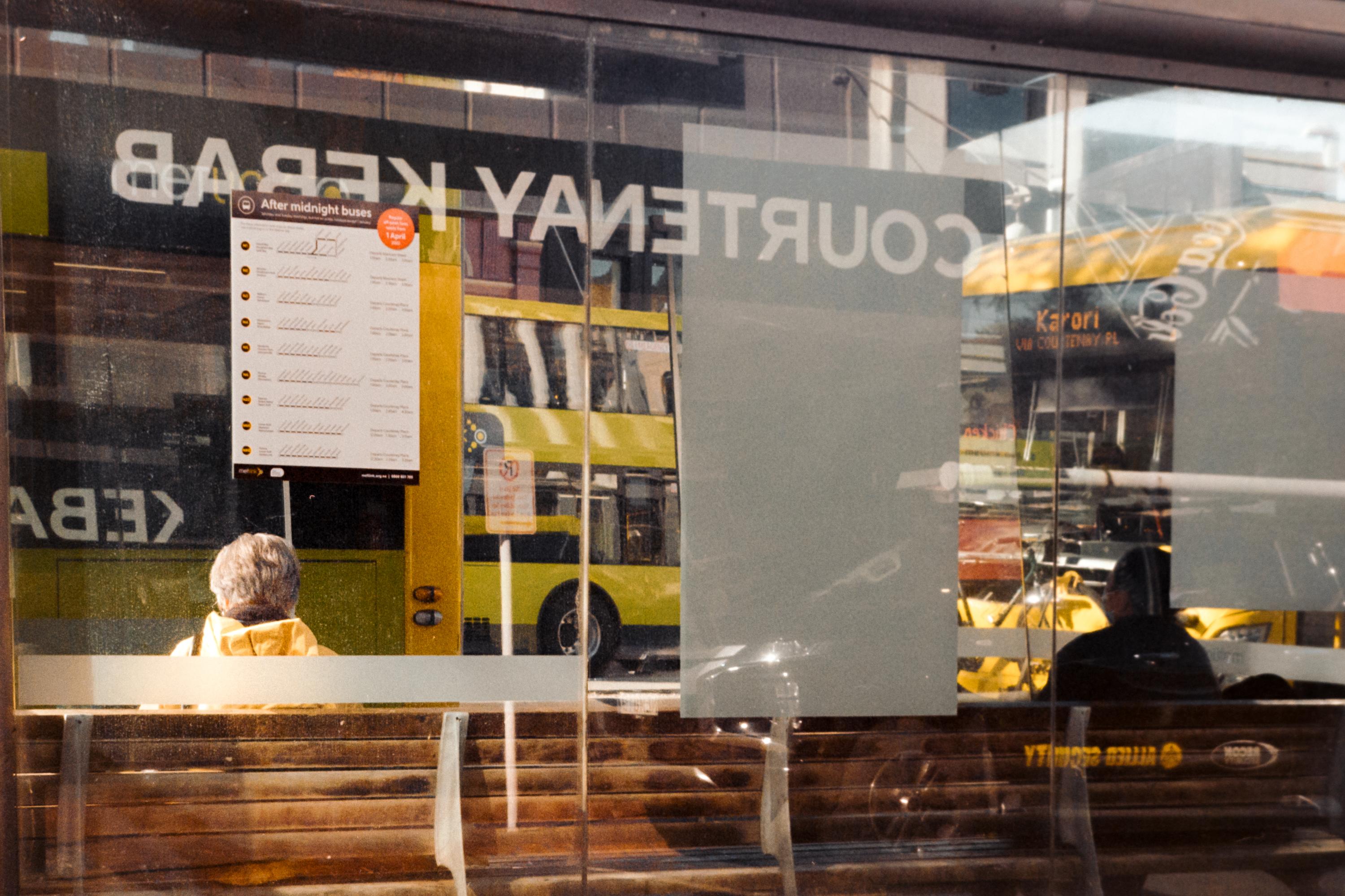 Photo of a woman sitting at a bus stop 