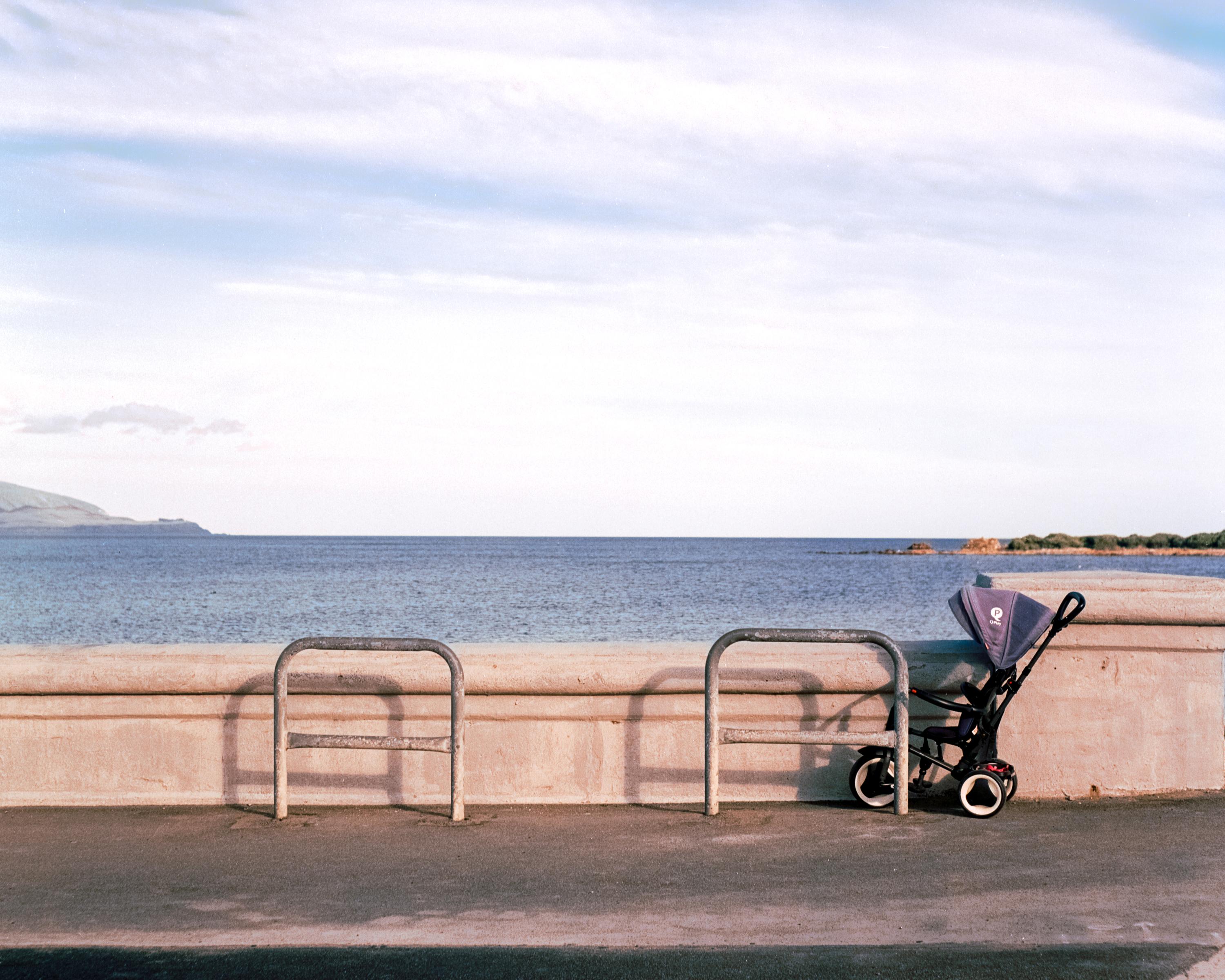 Photo of a pram against a sea wall