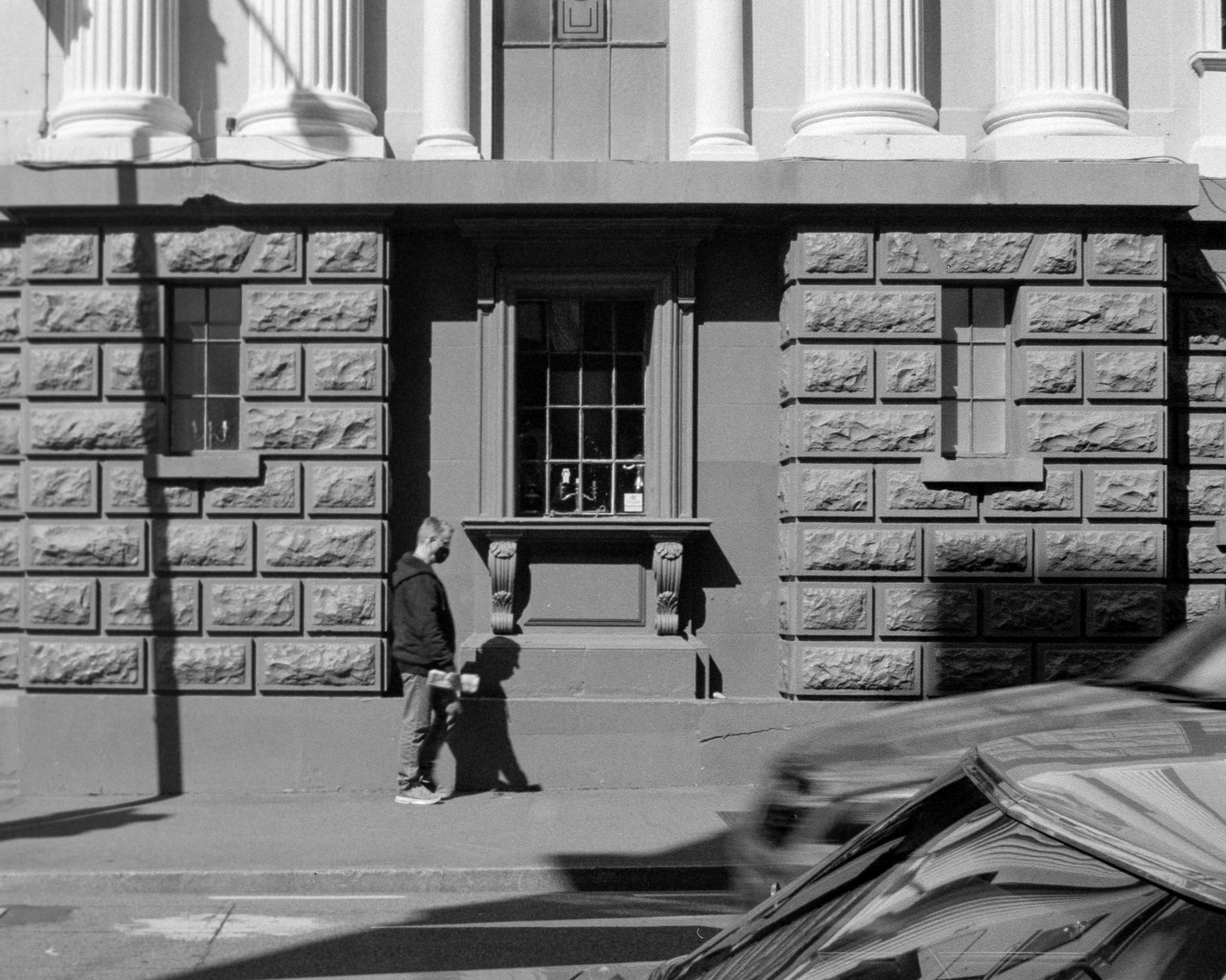 Photo of a man standing against a wall 